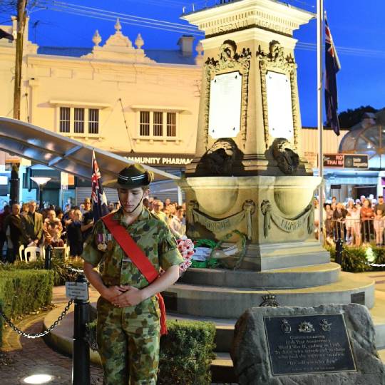 a young man in an Army uniform stands in front of Balmain's Loyalty Square monument