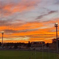 Orange sky behind a football field