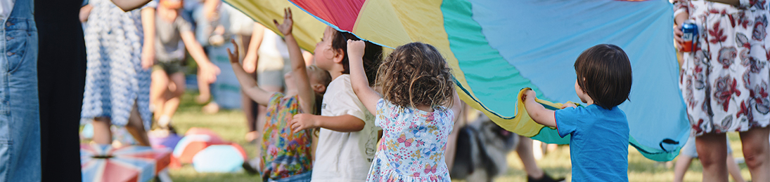 young children under a colourful parachute