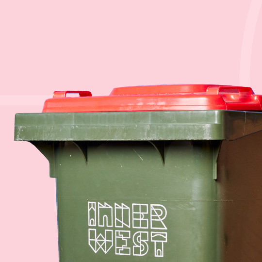 A red-lidded Inner West kerbside garbage bin