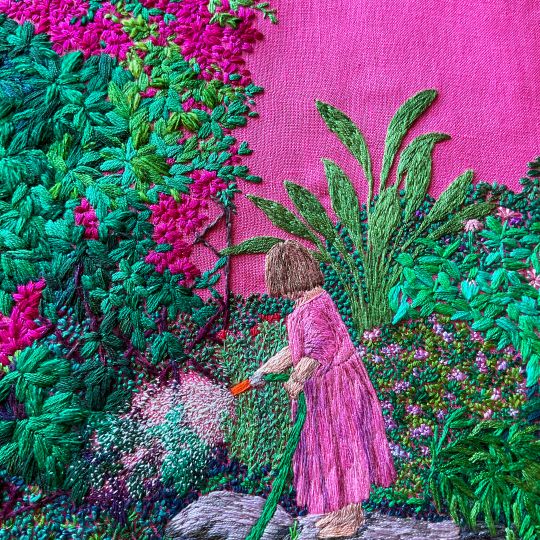 An embroidered artwork of a girl in a pink dress watering the garden
