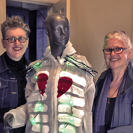 ARTeConect duo Tara and Liz with mannequin wearing student artwork 