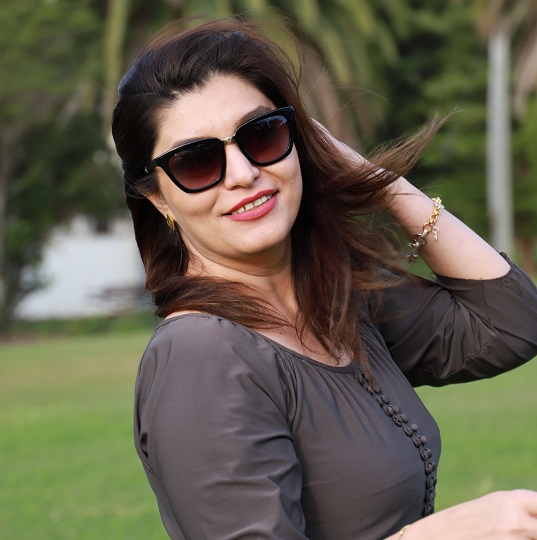 Artist Elham Marvi poses for camera, dark long hair, sun glasses, elegant woman