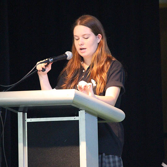  Highschool student speaking at a podium