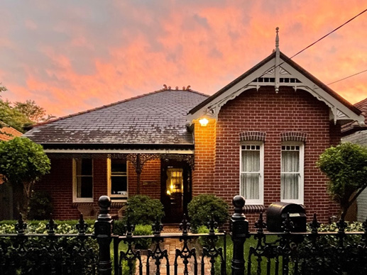 A front view of a well-kept historical brick house.