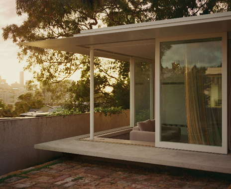 The back of a house with large glass sliding windows.