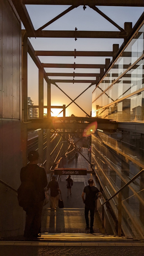 A stairway at a suburban railway station at sunset