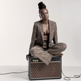 Woman sits atop an amplifier