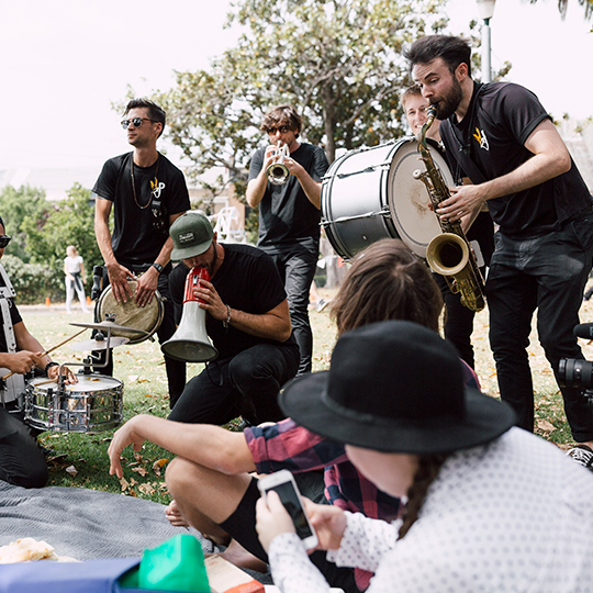 musicians play to people sitting in a park
