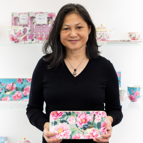 Smiling woman holds a floral handbag