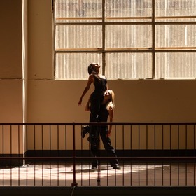 Moody sepia shot of dancers in a warehouse