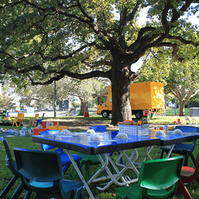 Park with trees and a big yellow bus in the background