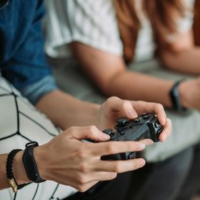 Close up of two people holding video game controllers