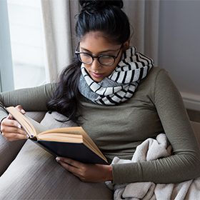 Woman reading book on sofa