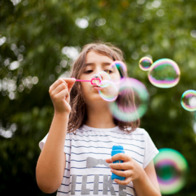 Young girl blowing bubbles