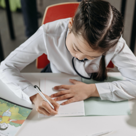 Young girl writing in a book