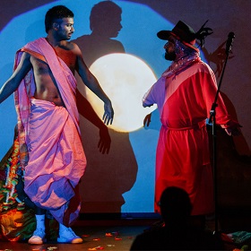 Performers on stage, shadows, pink clothing