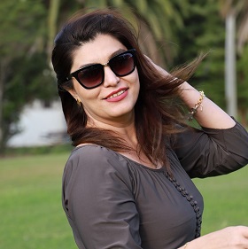 Artist Elham Marvi poses for camera, dark long hair, sun glasses, elegant woman