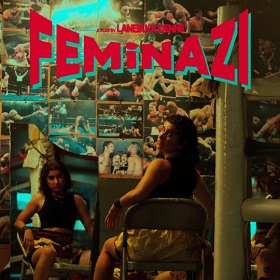 Photo of a person wwith dark shoulder length hair wearing silk boxing shorts, they sit  on a tin chair with their back to the camera but are turning to look at the camera with eyebrows raised, the room they are sitting in has a mirror that reflects the same person but shows their face front on, in the background are lots of boxing photos, the photo has the words in bold red font "Feminazi" a play by Lanekka Denne