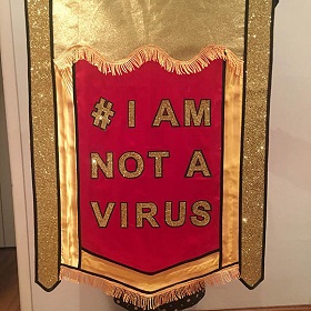 Embellished red and gold banner reads i am not a virus, gold tassels 