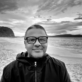 Black and white photo of Kenneth Craig Lambert on a beach