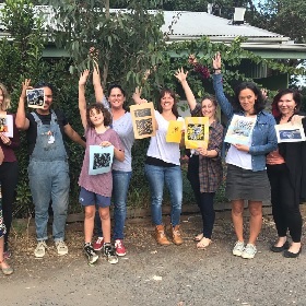 Photo of a group of people at Reverse Garbage holding up lino prints