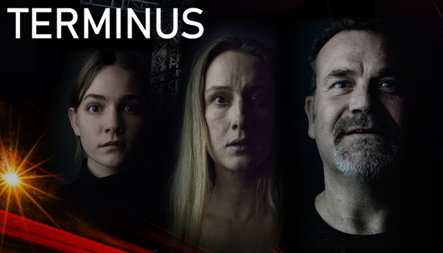Photo of three faces in a dark background the faces show different expressions of shock, fear and delight, the top left shows a bit of a scaffolding structure and the bottom mid righ shows red beams of light that shoot across the bottom of the photo, the word Terminus is written in white font accross the top of the photo