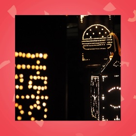 Night-time photo of There Will Always Be Light For You public artwork which includes tin cut metal lit up from inside - it looks like fairy lights showing shapes in the darkness
