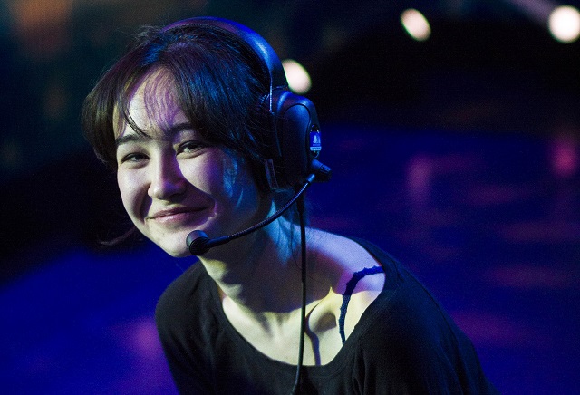 Photo of female actor with broad beautiful smile, earphones and microphone, blue tone on photo