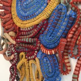 Woven sculpture in red blue and yellow wool
