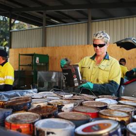 person inspecting paint can with gloves on