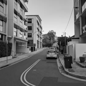 Black and white photo of a street of apartment blocks