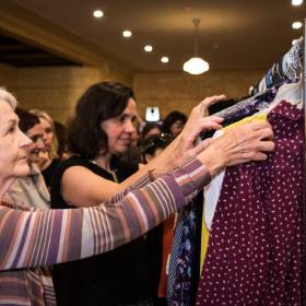 two women looking at rack of clothing