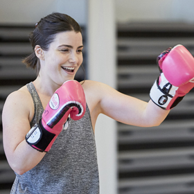 Woman wearing grey singlet boxing smiling