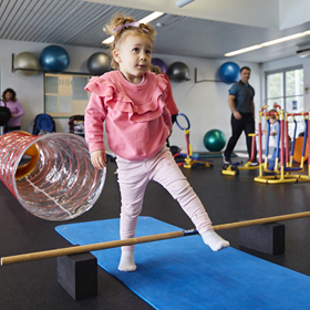 Little girl stepping over a bar