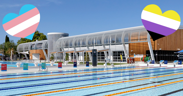 Photo of the outdoor pool at Ashfield Aquatic Centre with trans and gender diverse flags in the shape of hearts in the top left and right corners
