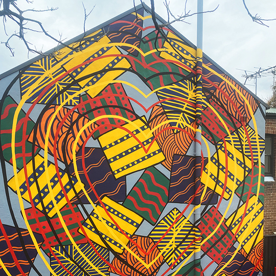 colourful Aboriginal deisgns painted on the side of a house.