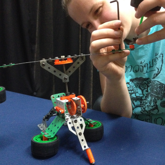 child building electronic machine out of small colourful components