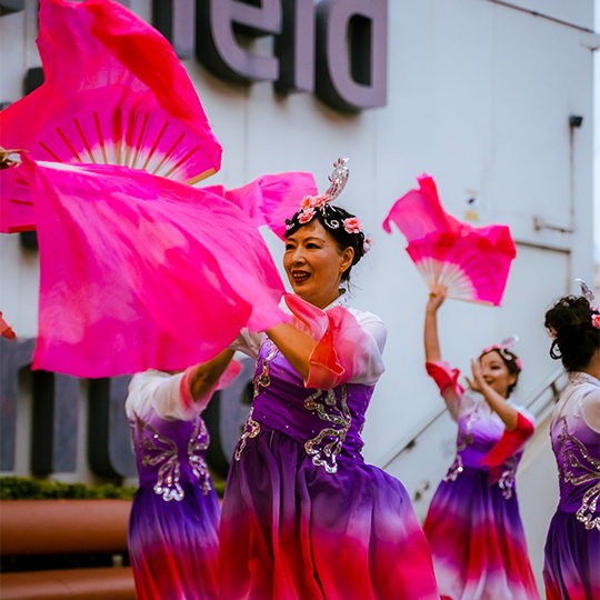 A woman in a pink dress dances outside