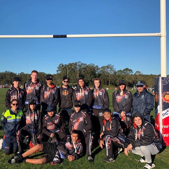 young NRL footballers standing in front of the goal posts on a football field