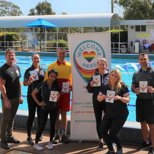 staff from LPAC and ACON standing in front of a pool