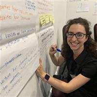 Forum participant taking notes in butchers paper 