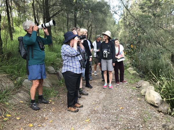 Group of people holding binoculars and laughing in Tempe Lands area