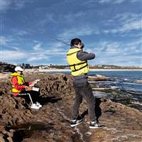 Man rock fishing and wearing a life jacket