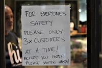 Community History - Social distancing sign outside the butcher