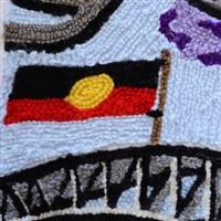 Tapestry threads show a design of the Aboriginal flag flying ontop of the harbour bridge, blue sky in background