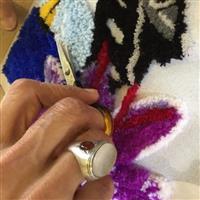 Artists hands (Sayd) uses scissors to cut the wool