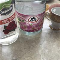 Two bottles of rosewater with pretty roses on labels - biscuit mold sits beside bottles