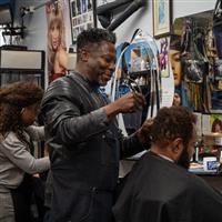 Two hair salon staff tending to customers