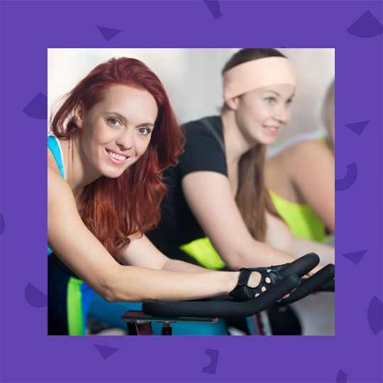 Two people on stationary bikes